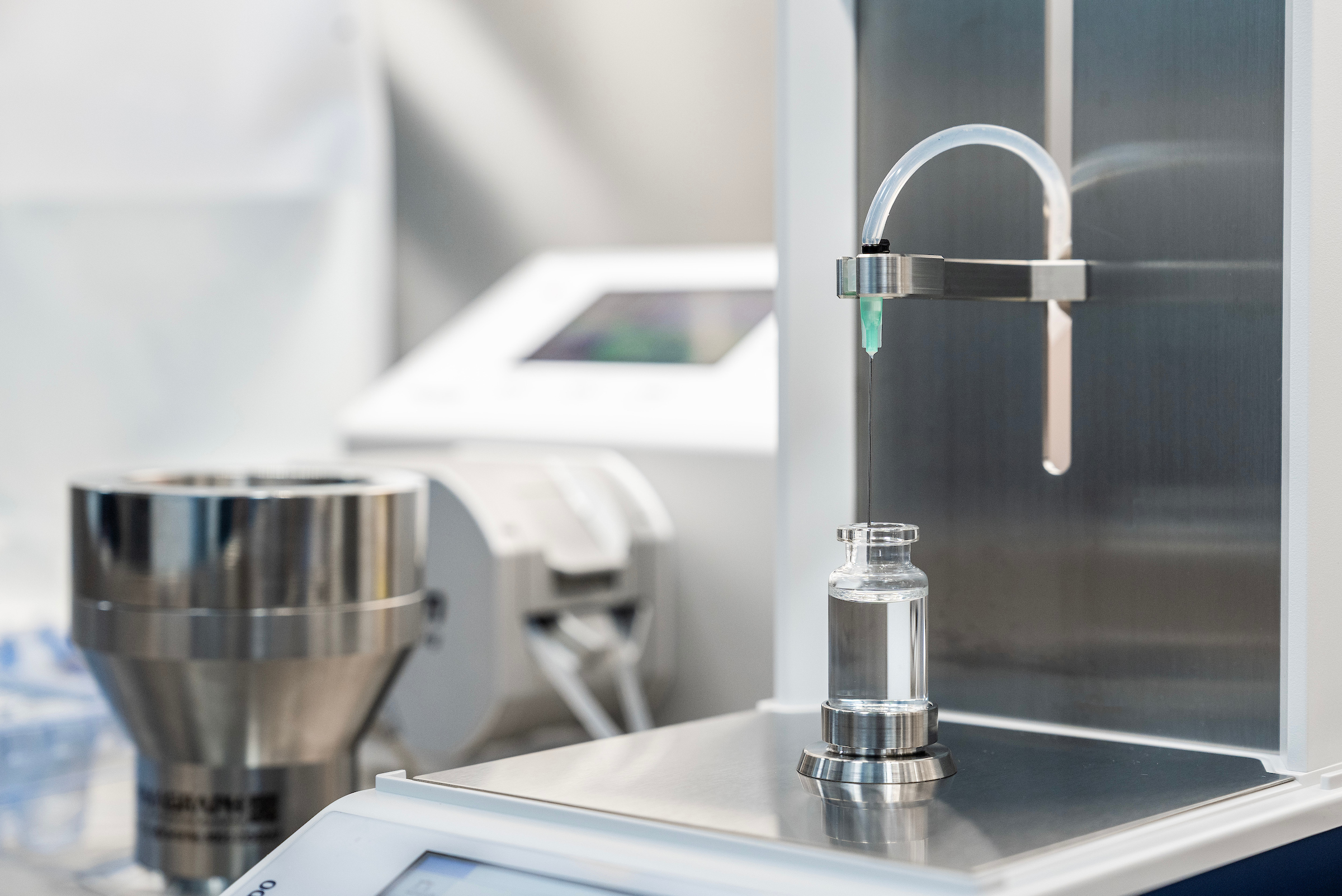 Sterile fill-finish facility with liquid filling a vial.